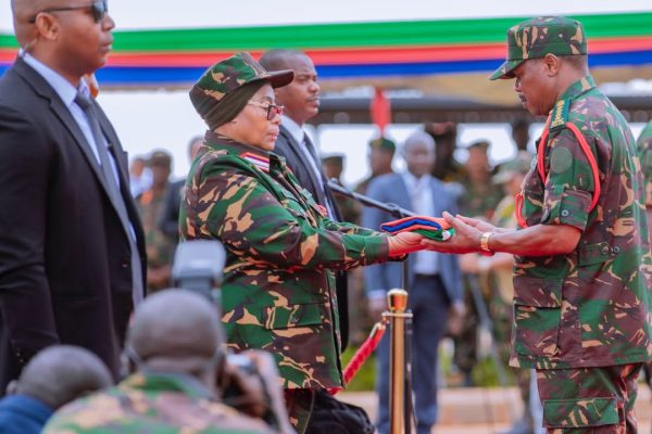 resident Samia Suluhu Hassan handing over the national flag to Chief of Defence Forces General Jacob John Mkunda at the National Defence Headquarters (MMUT) in Dodoma on 24 February 2026.