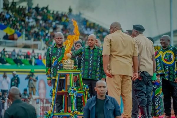 Zanzibar President Dr. Hussein Ali Mwinyi lighting the 2026 National Uhuru Torch at Gombani Stadium, Chake Chake, South Pemba, surrounded by officials and citizens