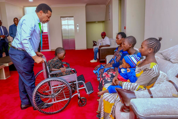 Mwigulu Nchemba handing over a wheelchair to Helena Joseph Mwandu at the Prime Minister’s Office in Dodoma.