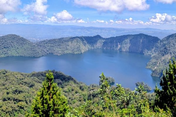 Scenic view of Lake Ngosi surrounded by misty forests and volcanic hills in Mbeya Region, showcasing one of Tanzania’s hidden natural wonders.