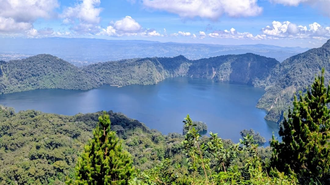 Scenic view of Lake Ngosi surrounded by misty forests and volcanic hills in Mbeya Region, showcasing one of Tanzania’s hidden natural wonders.