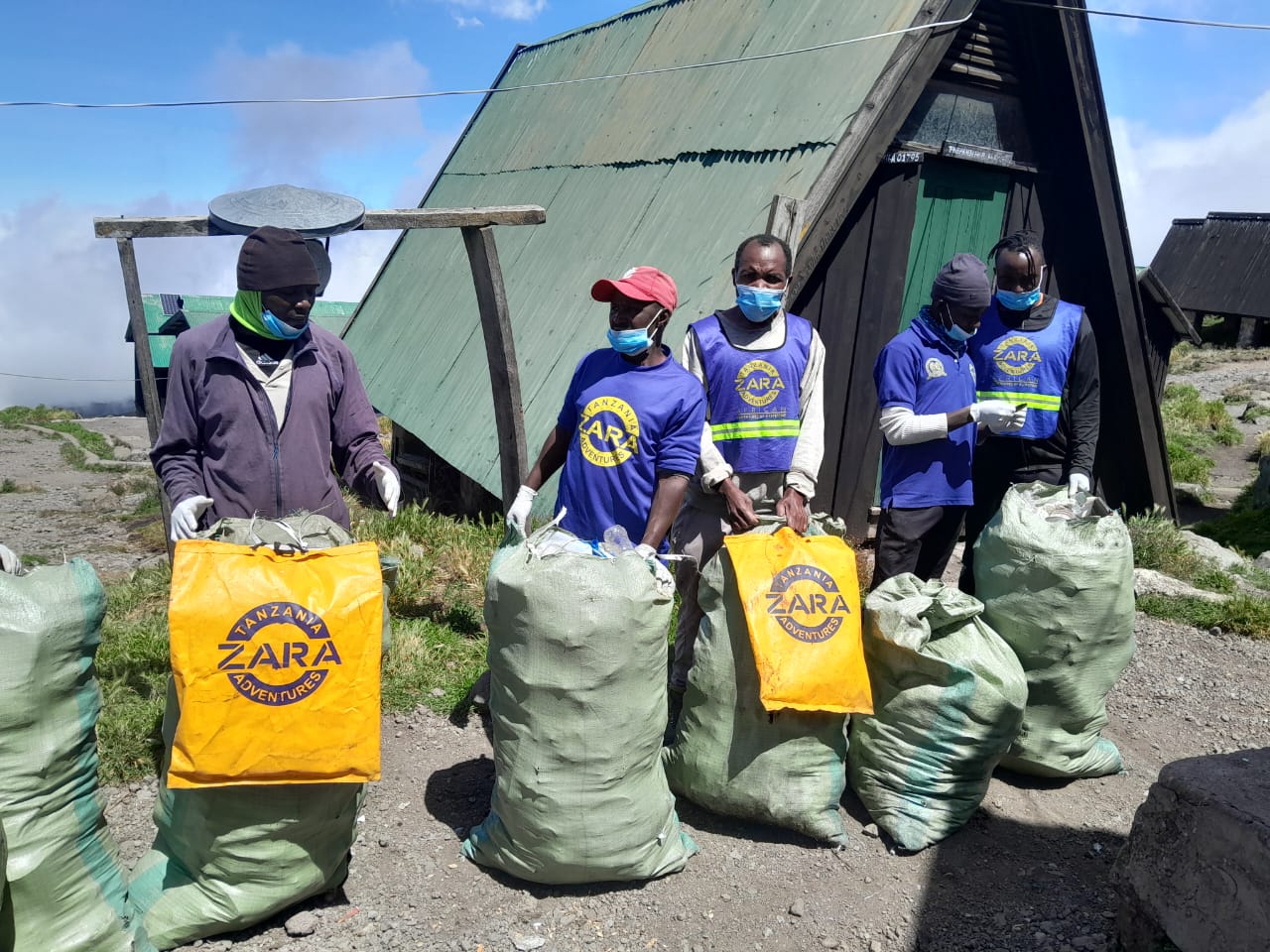 Environmental conservation teams from Zara Tanzania Adventures and Kilimanjaro National Park conducting a clean-up operation on Mount Kilimanjaro to support sustainable tourism and environmental protection.