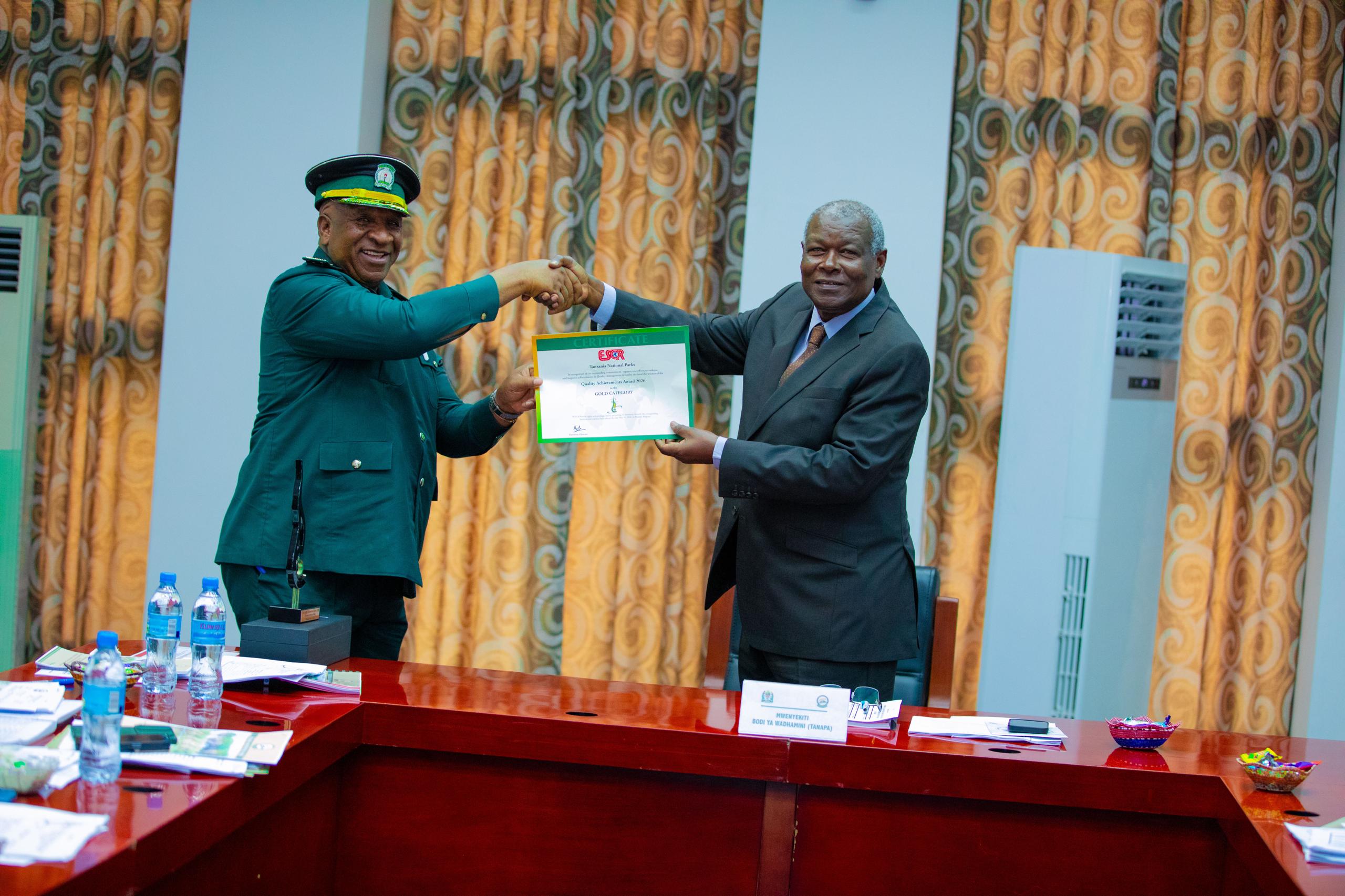 TANAPA Board of Trustees receiving Quality Achievement Award 2026 and National Quality Awards certificate from TANAPA management during an official ceremony in Dar es Salaam.
